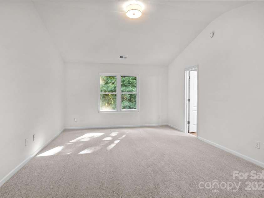 2532 Blue Moss Drive, Dallas, NC 28034.  MLS# CAR4271917, YatesRealty ID 21069. Large primary suite with vaulted ceiling, new light fixture, freshly painted walls and ceiling, brand new carpet and pad + en-suite bathroom.