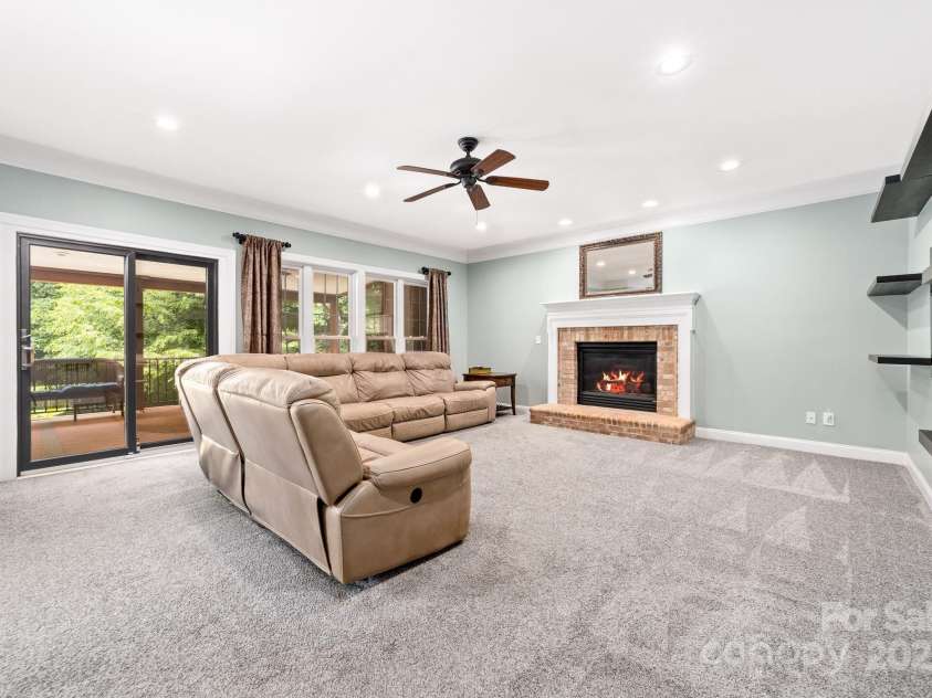 12002 Cobham Court, Huntersville, NC 28078.  MLS# CAR4269076, YatesRealty ID 21134. Spacious den with fireplace leading out to the expansive deck