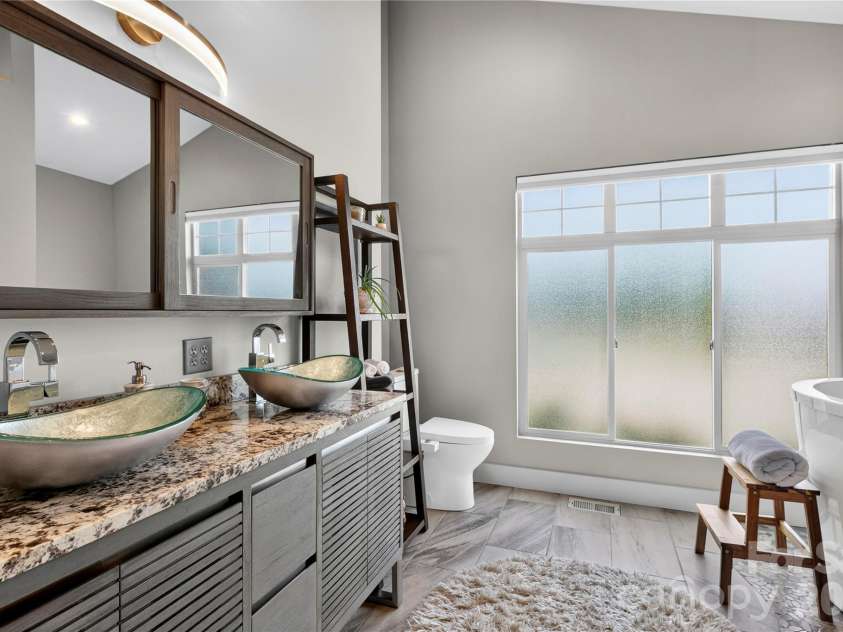 141 Round Top Circle, Mills River, NC 28759.  MLS# CAR4379751, YatesRealty ID 21136. Glass vessel sinks elevate the spa-inspired bath, complemented by abundant cabinet storage