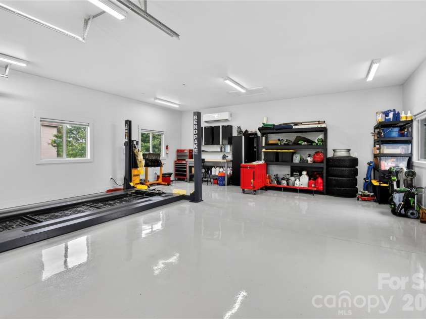 141 Round Top Circle, Mills River, NC 28759.  MLS# CAR4379751, YatesRealty ID 21136. The exceptional detached garage features a finished floor, temperature-controlled environment, excellent lighting, and heavy duty shelving, creating a versatile space ideal for vehicles, hobbies, or a workshop.