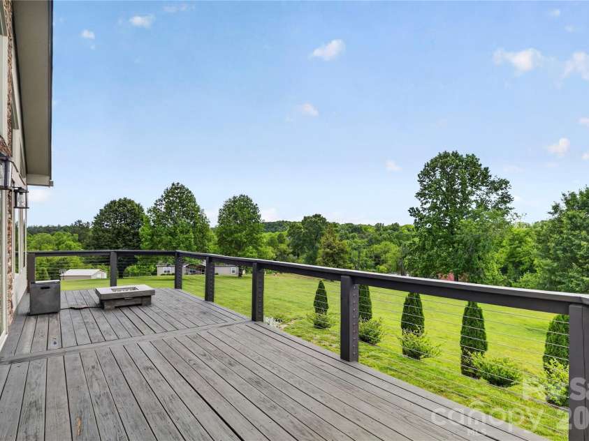 141 Round Top Circle, Mills River, NC 28759.  MLS# CAR4379751, YatesRealty ID 21136. The expansive deck showcases beautiful views, with cable railing designed to maximize visibility and preserve the scenery.
