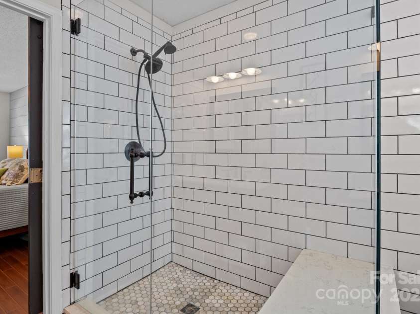 8700 Fox Tail Lane, Huntersville, NC 28078.  MLS# CAR4269110, YatesRealty ID 21136. A highlight of the primary bathroom is the extra-large shower beautifully finished with classic subway tile and enclosed by a sleek glass door.
