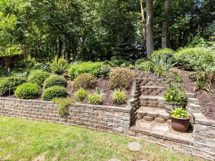 8700 Fox Tail Lane, Huntersville, NC 28078.  MLS# CAR4269110, YatesRealty ID 21136. Step out into a large private backyard beautifully landscaped. A stone retaining wall leads to an elevated garden.