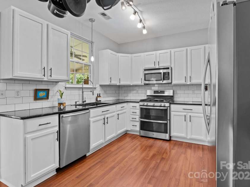 8700 Fox Tail Lane, Huntersville, NC 28078.  MLS# CAR4269110, YatesRealty ID 21136. This kitchen is both stylish and functional, featuring beautiful granite countertops and classic tile backsplash adding texture and easy-to-clean convenience perfectly complimenting the sleek finishes.