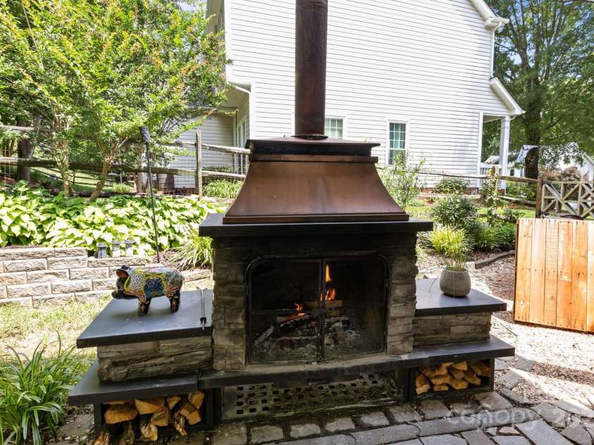 8700 Fox Tail Lane, Huntersville, NC 28078.  MLS# CAR4269110, YatesRealty ID 21136. This wood-burning fireplace becomes a cozy focal point for chilly evenings. Whether you are enjoying a quiet morning or hosting guest, this outdoor living space is the perfect retreat.