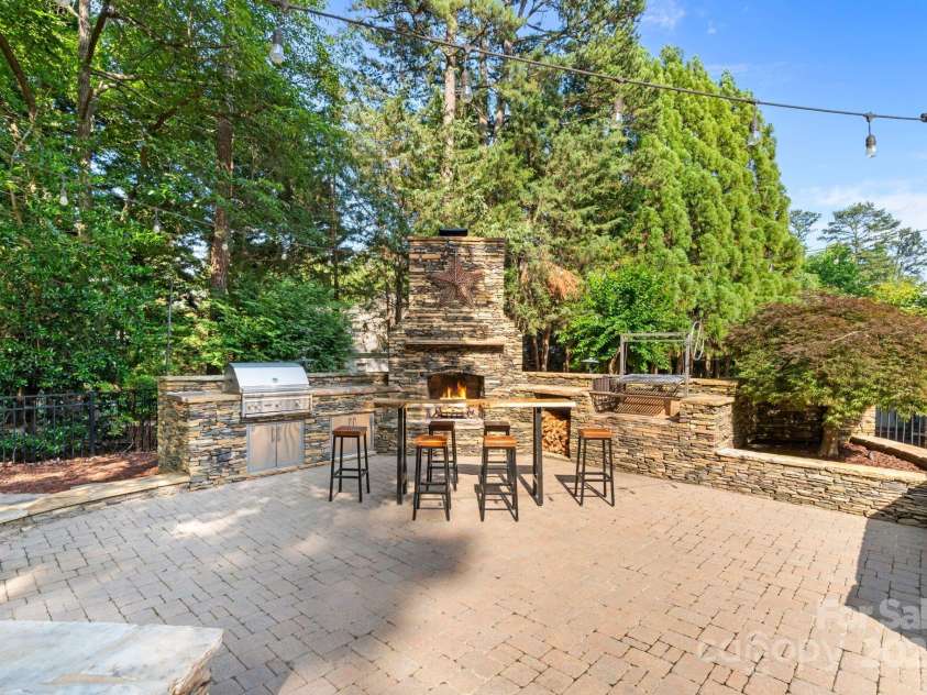 167 Quaker Road, Mooresville, NC 28117.  MLS# CAR4261192, YatesRealty ID 21144. Grilling area with gas grill and wood-fired Argentine grill.
