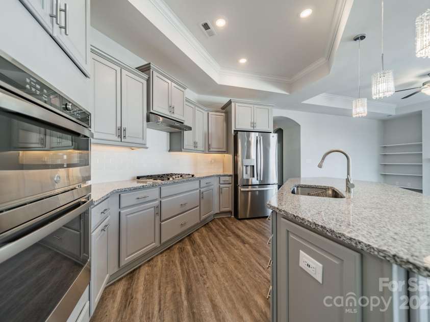 1005 Headwaters Court, Matthews, NC 28104.  MLS# CAR4233423, YatesRealty ID 21177. Undermount lighting with tile backsplash and granite countertops