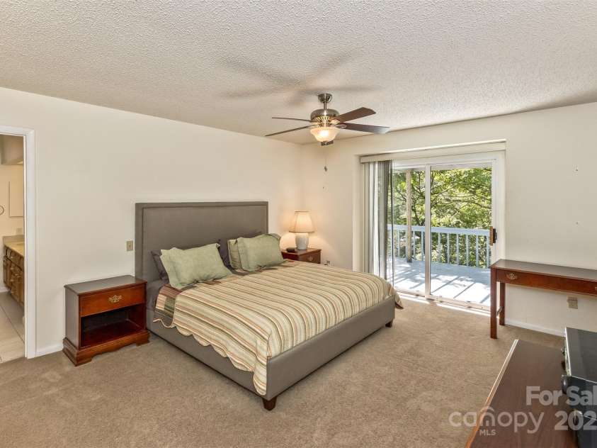 100 Black Oak Drive, Asheville, NC 28804.  MLS# CAR4266222, YatesRealty ID 21246. Primary bedroom with sliding door to the deck overlooking the woods