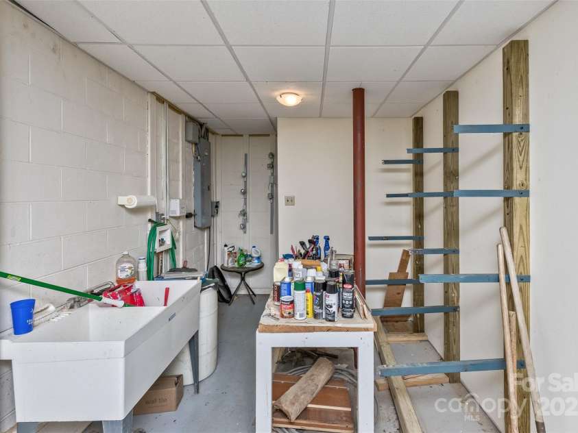 100 Black Oak Drive, Asheville, NC 28804.  MLS# CAR4266222, YatesRealty ID 21246. Workshop downstair plumbed with a double project sink.  Work benches and attached shelving stay with the home.