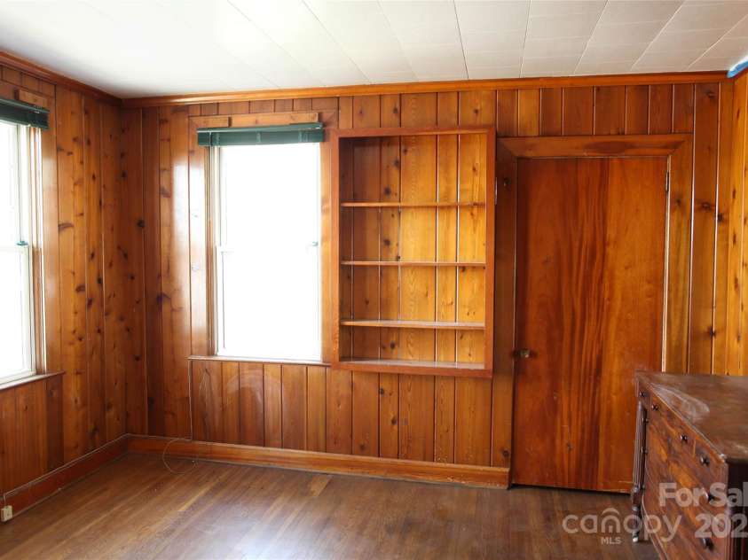55 Academy Avenue, Concord, NC 28025.  MLS# CAR4220777, YatesRealty ID 21248. Upstairs bedroom #2 with warm knotted wood paneling and built-in shelves