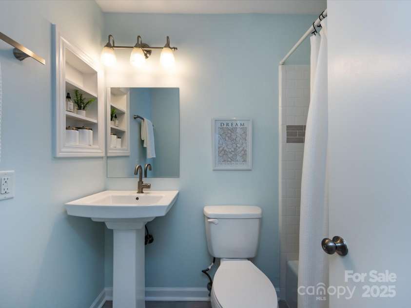 1708 Roxborough Road, Charlotte, NC 28211.  MLS# CAR4271759, YatesRealty ID 21279. Ensuite bath with pedastal sink, tiled tub/shower and wall niche.