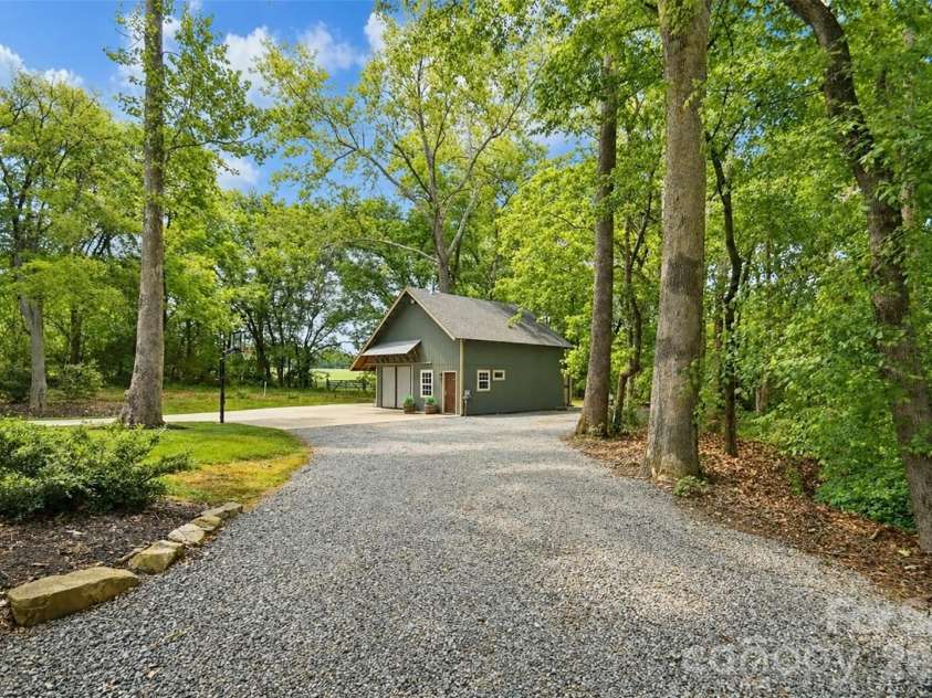 4484 Ranchway Drive, Concord, NC 28027.  MLS# CAR4375185, YatesRealty ID 21305. Detached workshop with private drive and spacious parking area, surrounded by mature trees for a peaceful, tucked-away setting