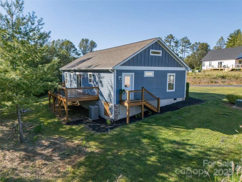 105 Bluebell Ridge Lane, Weaverville, NC 28787.  MLS# CAR4303351, YatesRealty ID 21393. Side view of home showing decks off laundry and dining rooms and crawl space storage.