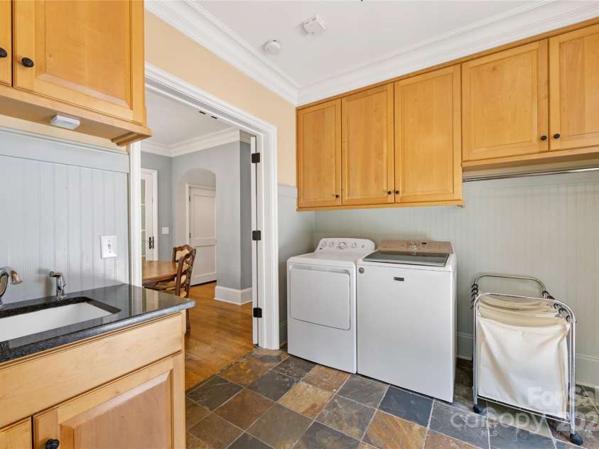 1728 Shadow Forest Drive, Matthews, NC 28105.  MLS# CAR4268214, YatesRealty ID 21441. Plenty of cabinetry & a sink in this great laundry room too!