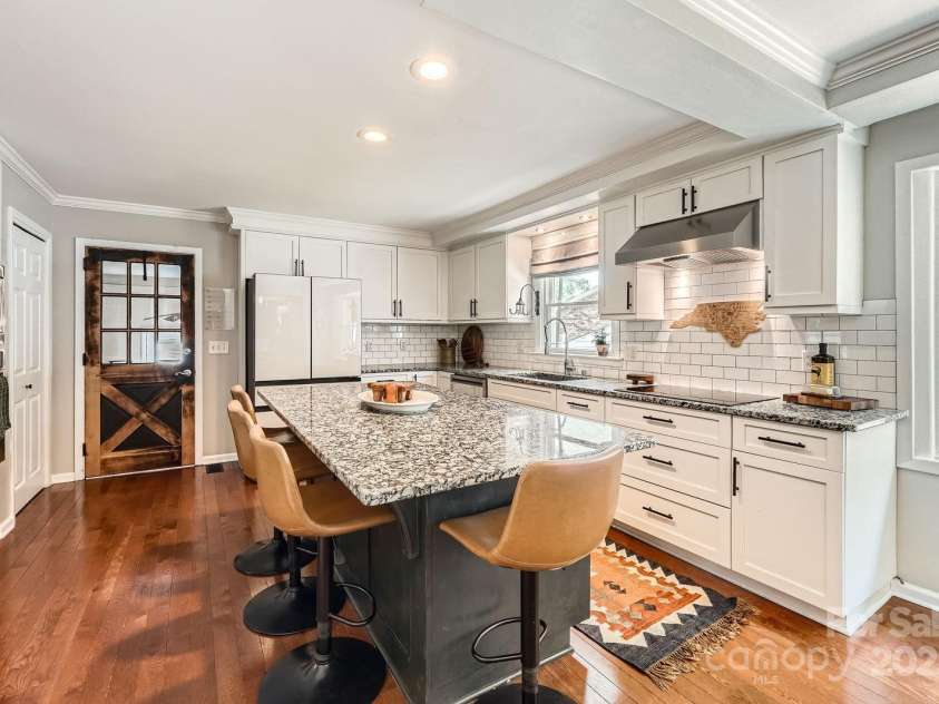 1175 18th Avenue, Hickory, NC 28601.  MLS# CAR4267840, YatesRealty ID 21483. This beautifully updated kitchen blends function and style with crisp white cabinetry, sleek granite countertops, and a contrasting center island that adds both workspace and character. A subway tile backsplash, and stainle