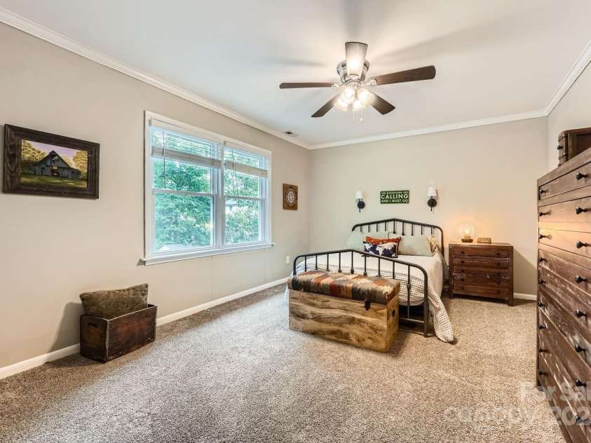 1175 18th Avenue, Hickory, NC 28601.  MLS# CAR4267840, YatesRealty ID 21483. Versatile Secondary Bedroom with Tree-Lined Views. This bright and comfortable secondary bedroom features soft carpeting, crown molding, and a neutral palette that complements any style. A large window overlooks the backyar
