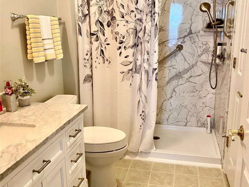 101 Keswick Lane, Mooresville, NC 28117.  MLS# CAR4317962, YatesRealty ID 21518. Primary Bathroom with walk in shower & wooden pulled down seating.