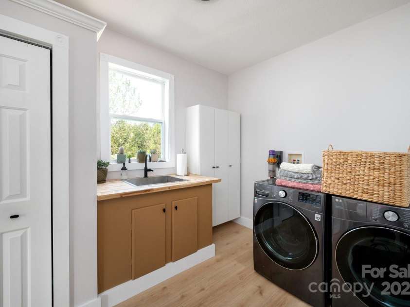 44 White Thorn Drive, Alexander, NC 28701.  MLS# CAR4253765, YatesRealty ID 21522. Laundry room with new sink, coutner top, floors and cabinet