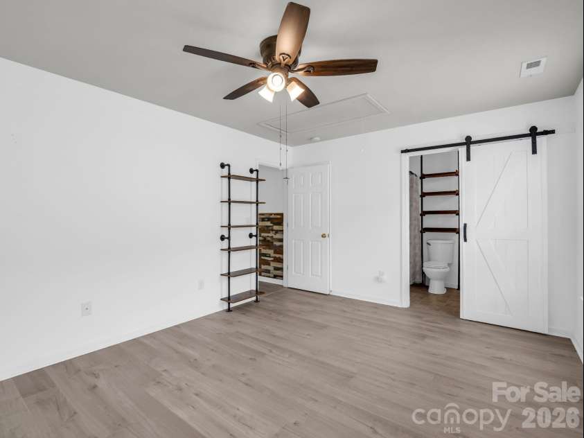 64 Lanceford Circle, Fletcher, NC 28732.  MLS# CAR4374412, YatesRealty ID 21576. Primary bedroom with barn door to bath