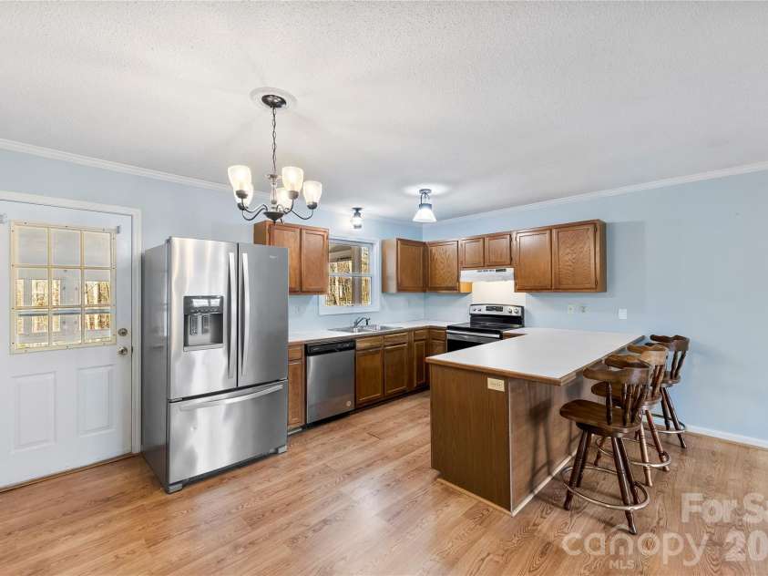 213 Woodrun Drive, Mount Gilead, NC 27306.  MLS# CAR4334949, YatesRealty ID 2158. Open living room flows seamlessly into the kitchen, giving you the space to gather, unwind, and enjoy the lake lifestyle year-round.