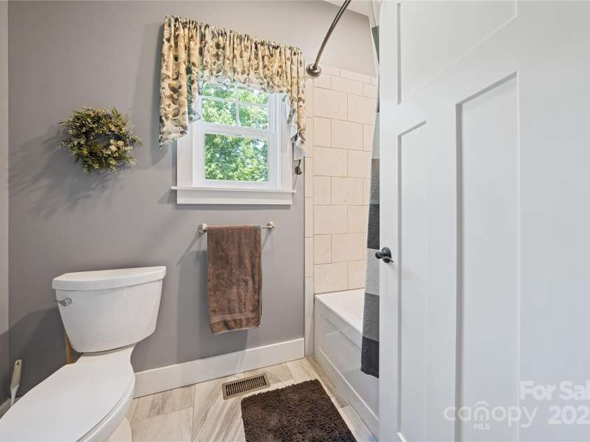 156 Olivet Lane, Fletcher, NC 28732.  MLS# CAR4272204, YatesRealty ID 21590. Guest bathroom separate room area with commode, tub with tile surround