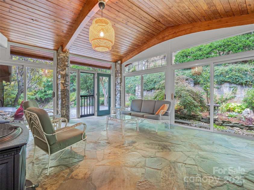 605 Upper Sondley Drive, Asheville, NC 28805.  MLS# CAR4304223, YatesRealty ID 21594. Inviting garden room with a Jotul gas stove and charming stone flooring.
