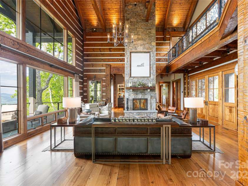 511 Asgi Trail, Maggie Valley, NC 28751.  MLS# CAR4258504, YatesRealty ID 21595. Double sided floor to ceiling stone fireplace anchors the warm and open great room