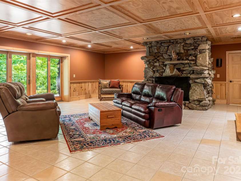 303 Flying Hawk Trail, Waynesville, NC 28786.  MLS# CAR4272138, YatesRealty ID 21603. Lower level family room with wood burning fp