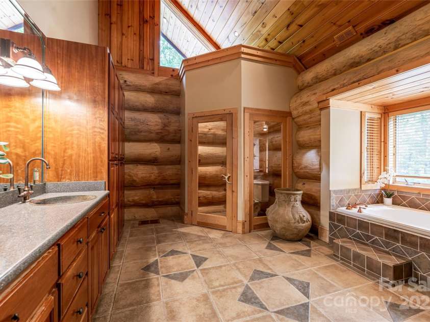 303 Flying Hawk Trail, Waynesville, NC 28786.  MLS# CAR4272138, YatesRealty ID 21603. The primary bath offers a soaking tub, full walk in shower, double vanitys and vaulted ceilings