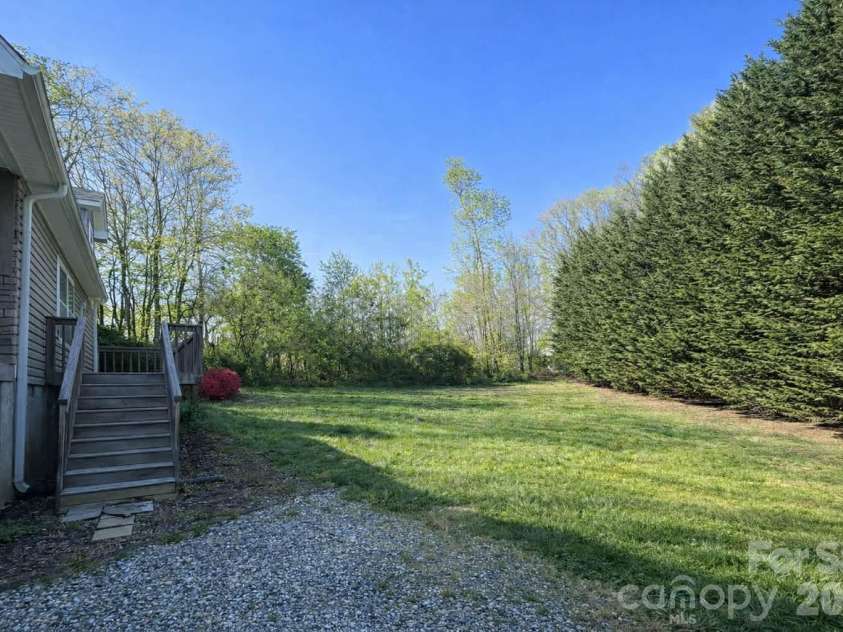 25 Eastwind Lane, Candler, NC 28715.  MLS# CAR4367557, YatesRealty ID 21619. The side yard as you can see is flat.