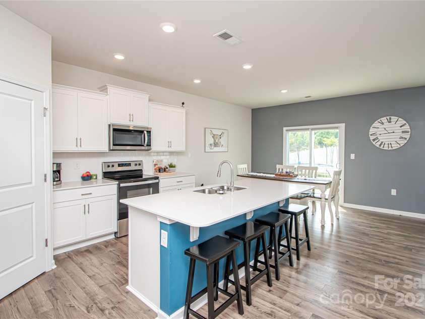 128 Hickory Ridge Drive, Locust, NC 28097.  MLS# CAR4270614, YatesRealty ID 21621. Kitchen is open to dinning area and family room.