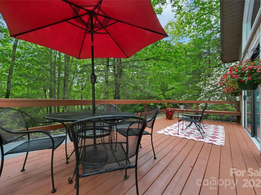 679 Soquili Drive, Brevard, NC 28712.  MLS# CAR4265115, YatesRealty ID 21674. Charming front deck nestled among the trees.