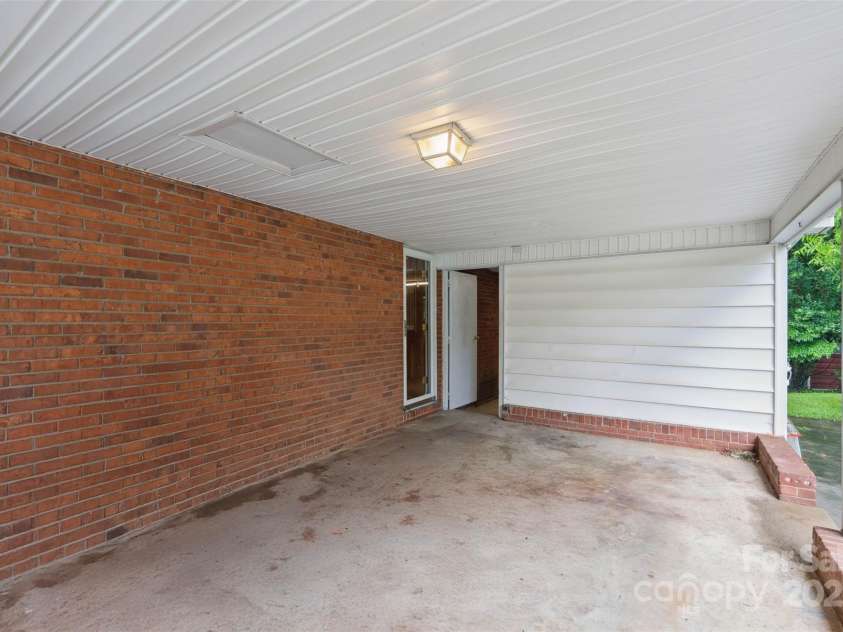 46 Donna Dale Avenue, Concord, NC 28025.  MLS# CAR4268171, YatesRealty ID 21700. From carport, door to the left is the back door leading into the kitchen and the white door leads into the storage room