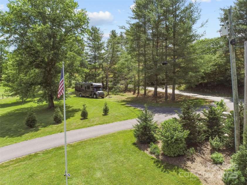 971 Banks Creek Road, Burnsville, NC 28714.  MLS# CAR4270100, YatesRealty ID 21780. Additional photo shows the RV site, conveniently situated just off the main driveway entrance. Complete with shade trees, a fire pit, and a picnic table for outdoor enjoyment