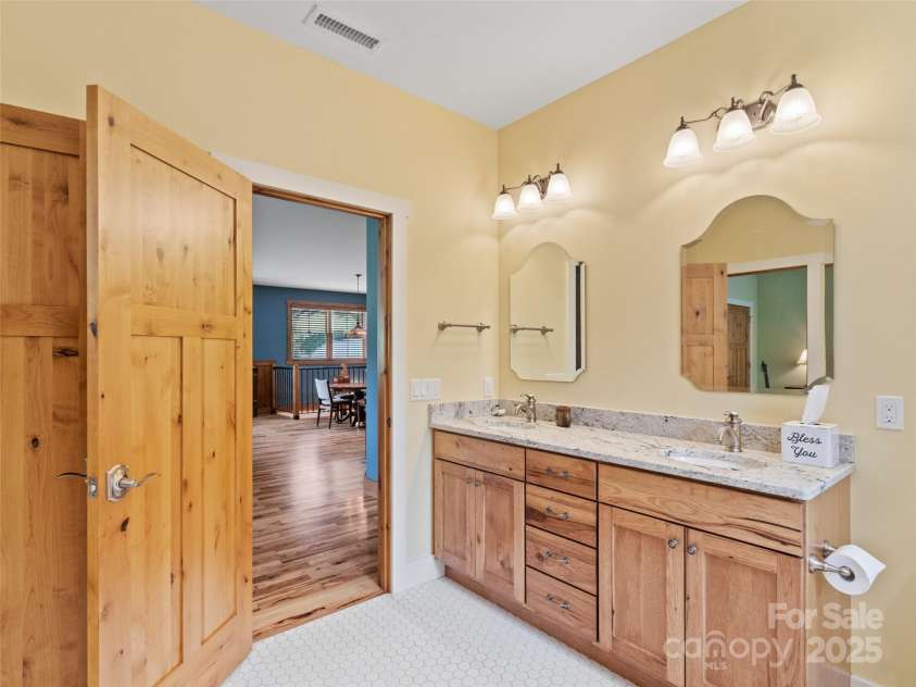 971 Banks Creek Road, Burnsville, NC 28714.  MLS# CAR4270100, YatesRealty ID 21780. Beautifully appointed bathroom featuring custom wood cabinetry and timeless tile flooring