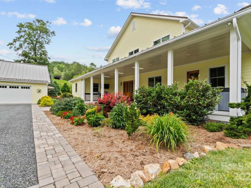 971 Banks Creek Road, Burnsville, NC 28714.  MLS# CAR4270100, YatesRealty ID 21780. One of the first features to capture your attention is the meticulously designed landscaping, highlighted by a vibrant pollinator garden.
