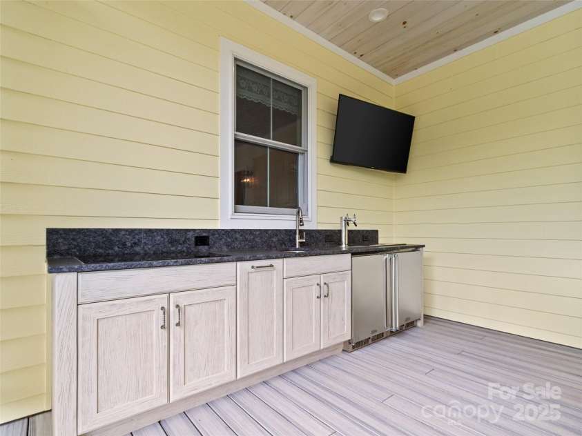971 Banks Creek Road, Burnsville, NC 28714.  MLS# CAR4270100, YatesRealty ID 21780. Outdoor entertaining is effortless with a kitchen that includes an induction cooktop, sink, beverage cooler, and keg machine.