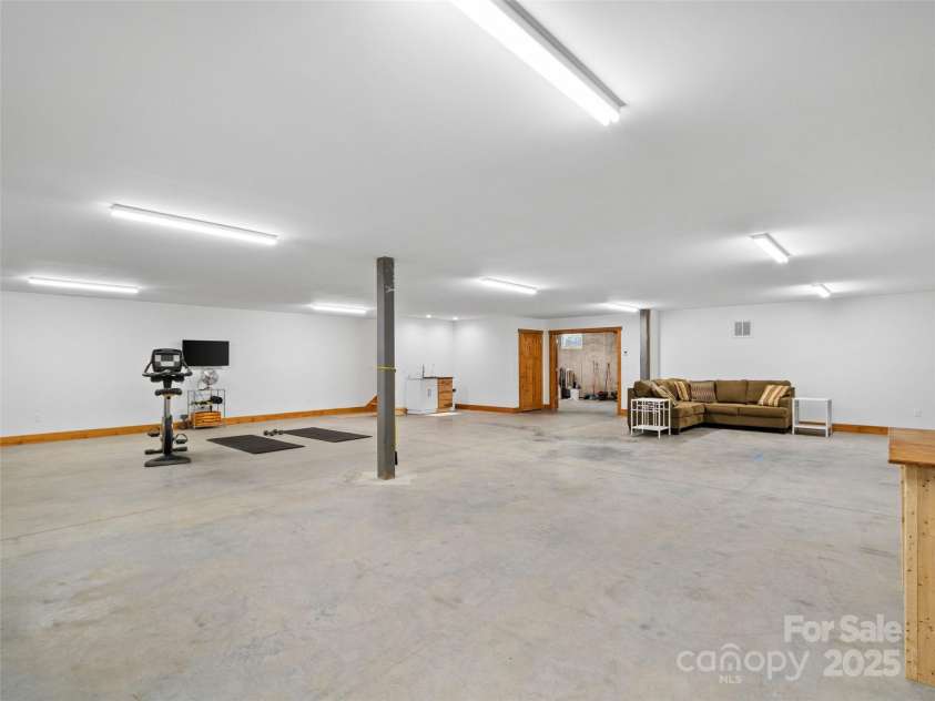 971 Banks Creek Road, Burnsville, NC 28714.  MLS# CAR4270100, YatesRealty ID 21780. With its generous footprint and separate outside entry, the basement level provides endless possibilities, whether you envision guest accommodations, a recreation space, or a personal studio.