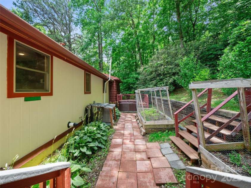125 Heartland Lane, Burnsville, NC 28714.  MLS# CAR4273356, YatesRealty ID 21808. Behind house, Hot Tub, Garden beds, Landscape