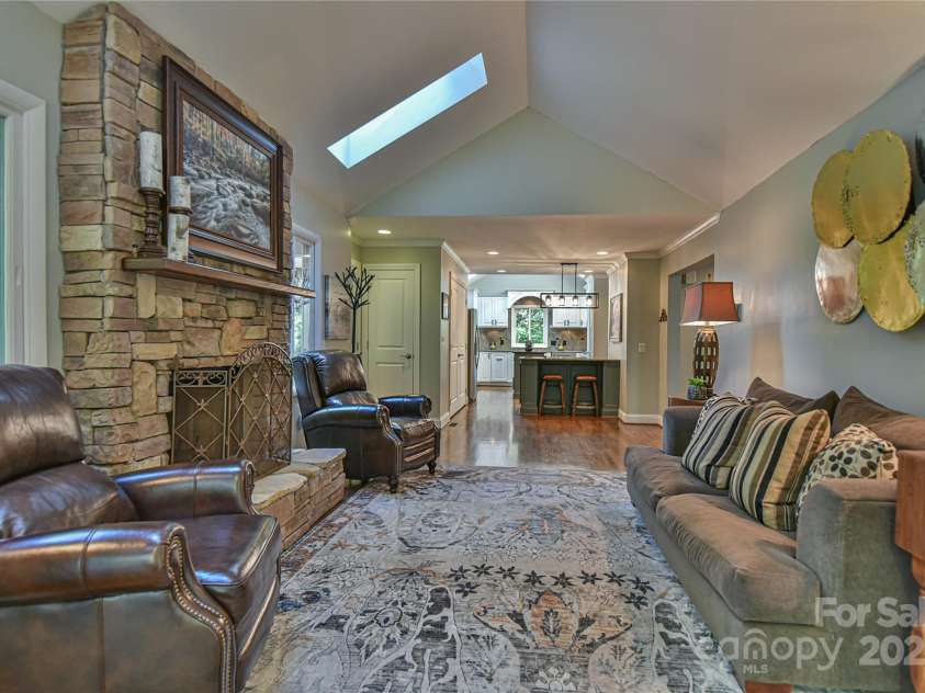 409 North Fork Road, Black Mountain, NC 28711.  MLS# CAR4284708, YatesRealty ID 2185. Keeping room off the kitchen features a floor to ceiling stone wood burning fireplace and an adjacent sunroom.