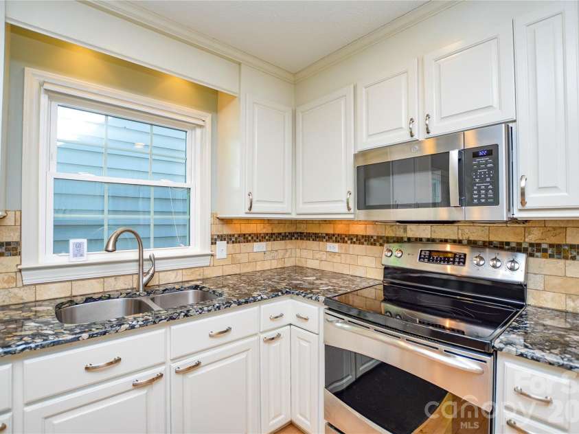 2922 Butter Churn Lane, Matthews, NC 28105.  MLS# CAR4361303, YatesRealty ID 21985. White kitchen with S/S appliances , granite counters 