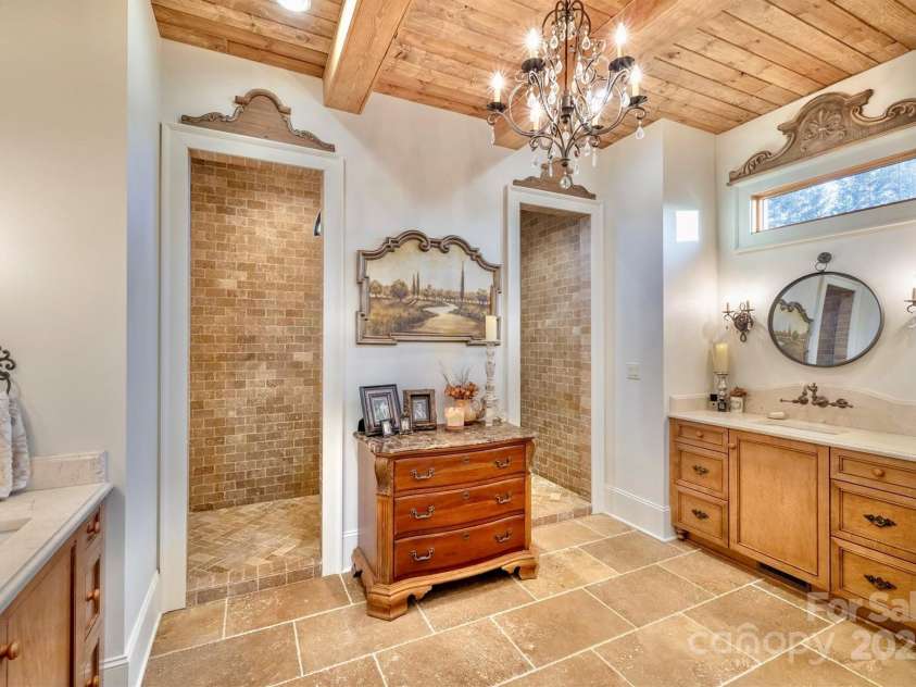 5608 Table View Lane, Lenoir, NC 28645.  MLS# CAR4232931, YatesRealty ID 2200. The bathroom in the ensuite primary bedroom has marble floors, 2 marble topped vanities, a large walk-in shower with 2 doorways and a 20