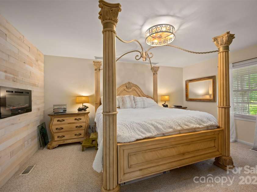 64 Persimmon Hill Drive, Columbus, NC 28722.  MLS# CAR4257157, YatesRealty ID 22038. Master Bedroom w/ electric fireplace & wood wall