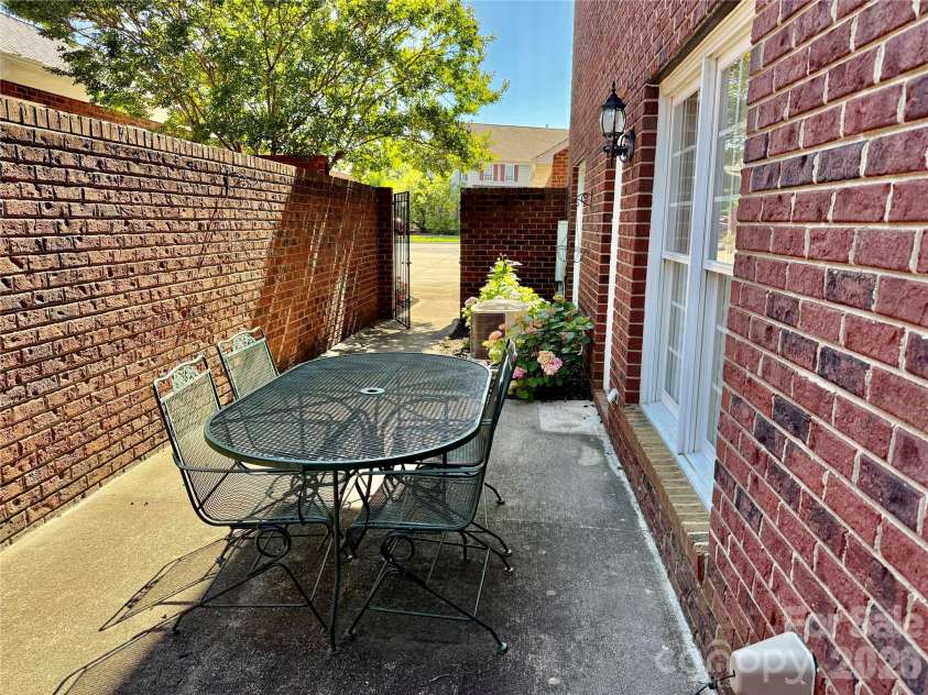 90 Huie Street, Concord, NC 28027.  MLS# CAR4379704, YatesRealty ID 22038. Private brick walled patio with iron gate