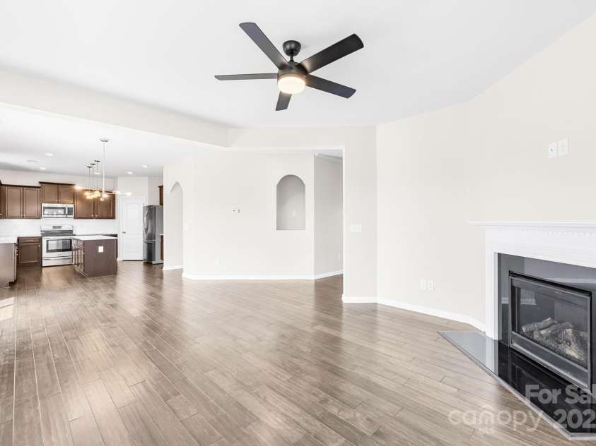 3022 Oakmere Road, Waxhaw, NC 28173.  MLS# CAR4249075, YatesRealty ID 22108. Open-concept family room with a cozy gas fireplace, ceiling fan, and a seamless flow into the kitchen and dining area.