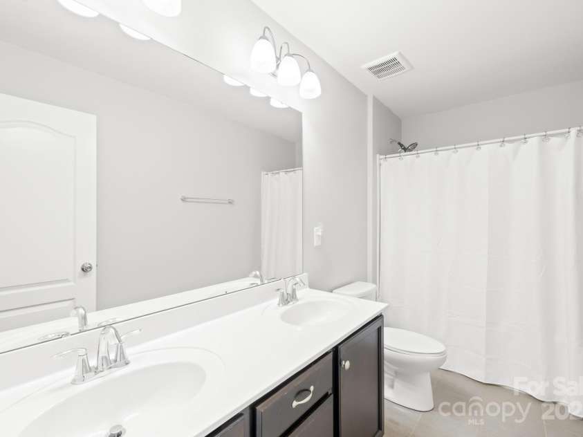 3022 Oakmere Road, Waxhaw, NC 28173.  MLS# CAR4249075, YatesRealty ID 22108. Upstairs hallway bathroom features dual vanities, modern fixtures and a tiled floor.