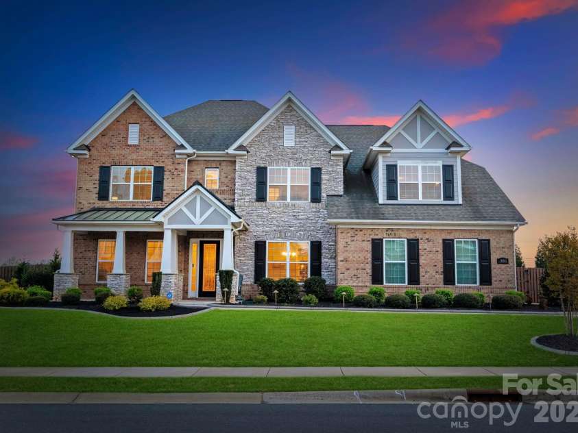 1053 Harlow's Crossing Drive, Matthews, NC 28104.  MLS# CAR4353232, YatesRealty ID 22111. Elegant full-brick front elevation with manicured landscaping and curb appeal