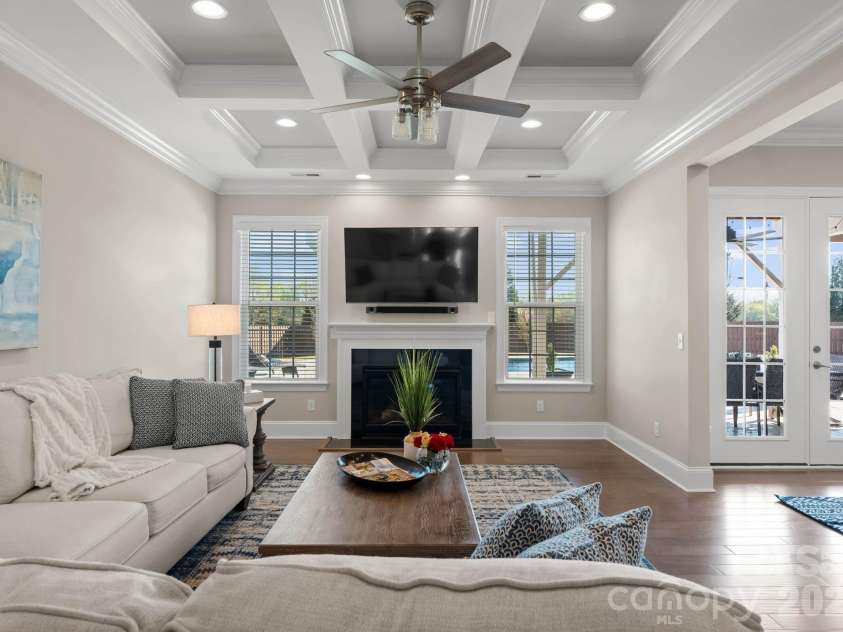 1053 Harlow's Crossing Drive, Matthews, NC 28104.  MLS# CAR4353232, YatesRealty ID 22111. Light-filled living room with coffered ceiling and fireplace