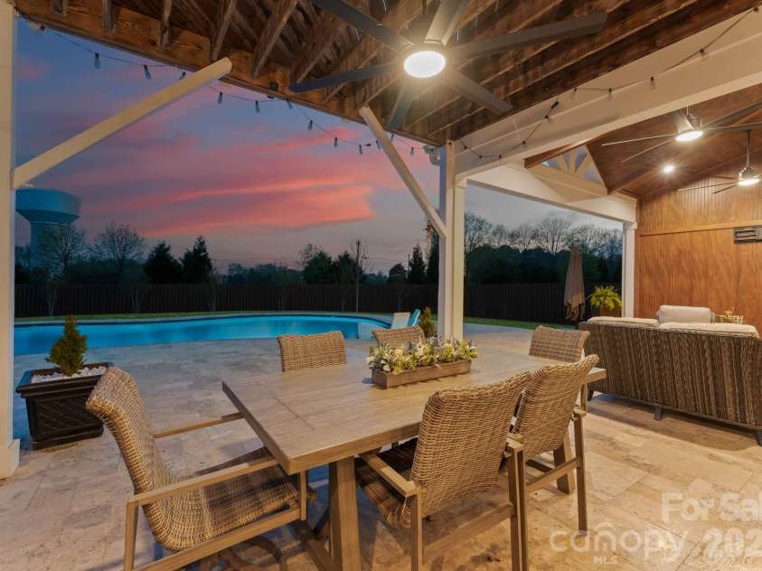 1053 Harlow's Crossing Drive, Matthews, NC 28104.  MLS# CAR4353232, YatesRealty ID 22111. Outdoor dining space overlooking pool and backyard