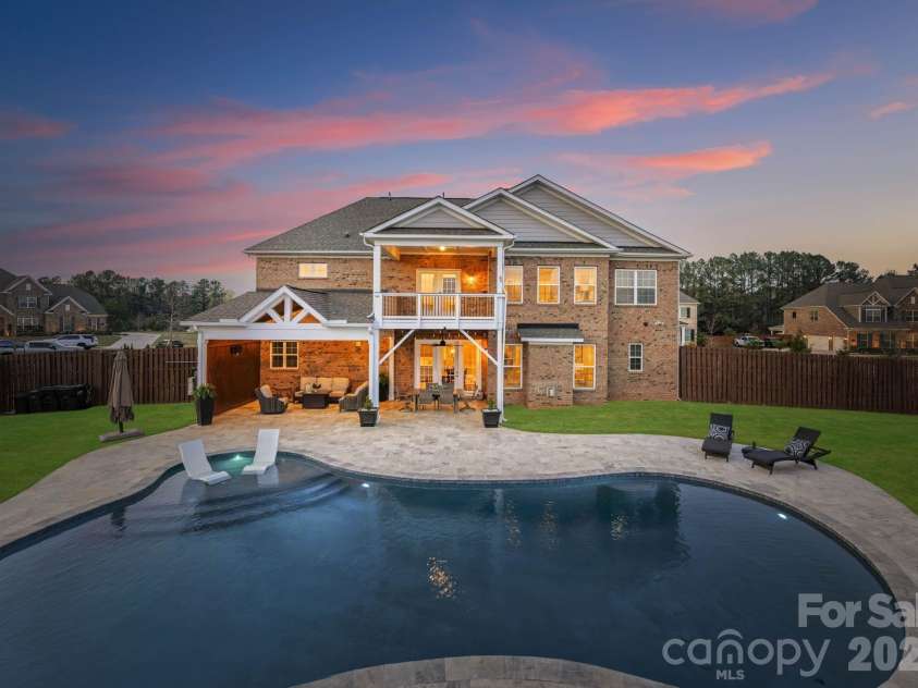 1053 Harlow's Crossing Drive, Matthews, NC 28104.  MLS# CAR4353232, YatesRealty ID 22111. Resort-style backyard with custom pool, covered patio, and expansive entertaining space